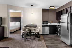 a small kitchen with a table and a bed at Residence Inn Atlanta Norcross/Peachtree Corners in Norcross