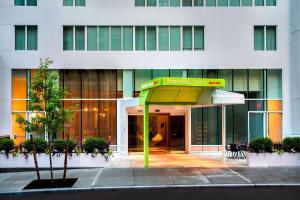 un edificio con una señal verde delante de él en SpringHill Suites by Marriott New York Midtown Manhattan/Fifth Avenue, en Nueva York