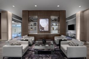 a living room with white couches and a tv at AC Hotel by Marriott Pittsburgh Southpointe in Canonsburg