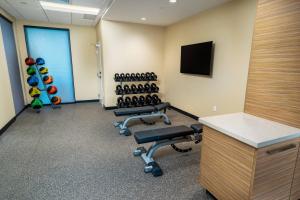 an office with a gym with dumbbells and a tv at TownePlace Suites Irvine Lake Forest in Lake Forest