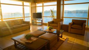 uma sala de estar com sofás e mesas e uma televisão em Patagonia Hotel em San Carlos de Bariloche