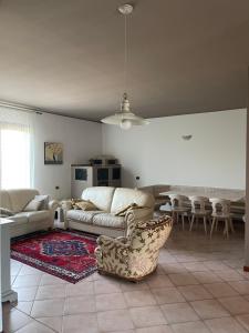 Marinella的住宿－Villa Marinella Apartments - Locazione Turistica，客厅配有沙发、椅子和桌子