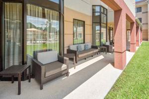 eine Terrasse mit Stühlen und Tischen auf einem Gebäude in der Unterkunft Courtyard by Marriott Bryan College Station in College Station