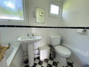 a bathroom with a toilet and a sink at 15 The Drive, Penstowe Holiday Park, Kilkhampton, Bude, Cornwall in Bude