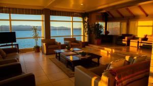 ein Wohnzimmer mit Sofas und Blick auf das Wasser in der Unterkunft Patagonia Hotel in San Carlos de Bariloche