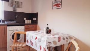 a kitchen with a table with a washing machine at Beauly Holiday Home in Beauly
