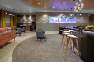 a lobby with a bar and some chairs and tables at SpringHill Suites Cincinnati North Forest Park in Springdale