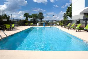 una piscina con sedie e acqua blu di SpringHill Suites Cincinnati North Forest Park a Springdale