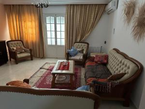 ein Wohnzimmer mit 2 Sofas und einem Tisch in der Unterkunft Résidence TANTANA in Chott Meriem