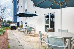 a patio with tables and chairs with umbrellas at SpringHill Suites Shreveport-Bossier City/Louisiana Downs in Bossier City