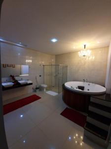 a large bathroom with a tub and a toilet at Hotel e Locadora Vizon in Vilhena