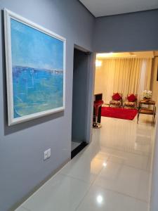 a living room with a painting on the wall at Hotel e Locadora Vizon in Vilhena