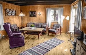 HjelmelandにあるAwesome Home In Skiftun With House Sea Viewのリビングルーム(椅子、テーブル、テレビ付)
