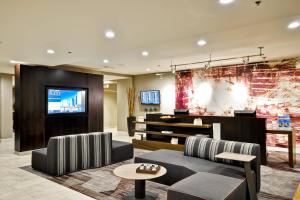a lobby with a couch and chairs and a tv at Courtyard by Marriott Jacksonville Airport/ Northeast in Jacksonville