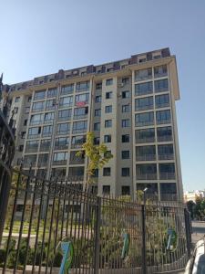 un edificio alto con una valla delante en Apartment seven B, en Tashkent