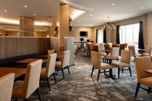 a restaurant with tables and chairs and a bar at Fairfield Inn & Suites By Marriott Louisville Northeast in Louisville