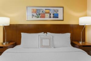 ein Schlafzimmer mit einem weißen Bett mit zwei Lampen in der Unterkunft Fairfield Inn and Suites by Marriott Tampa Brandon in Tampa