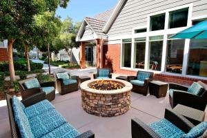 a patio with chairs and a fire pit in front of a building at Residence Inn Milpitas Silicon Valley in Milpitas