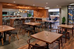 a restaurant with wooden tables and chairs and a bar at Fairfield Inn by Marriott Montreal Downtown in Montreal