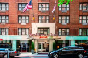 un bâtiment avec deux drapeaux américains devant lui dans l'établissement Residence Inn by Marriott New York Manhattan/ Midtown Eastside, à New York