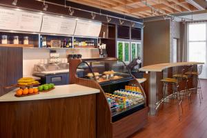 a restaurant with a counter with fruits and drinks at Courtyard by Marriott Kingston Highway 401 in Kingston