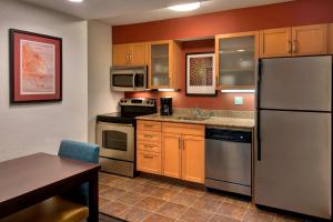 a kitchen with a stainless steel refrigerator and a table at Residence Inn Philadelphia Valley Forge in Berwyn