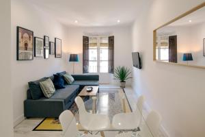 格拉纳达Granadi Apartamentos的带沙发、桌子和椅子的客厅