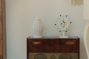 une commode avec un vase et un vase dessus dans l'établissement Masseria Egnazia - Epoca Collection, à Savelletri di Fasano
