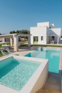 - une piscine en face d'une maison dans l'établissement Masseria Egnazia - Epoca Collection, à Savelletri di Fasano