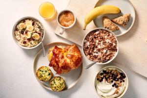 una mesa con platos de comida y bebida para el desayuno en Fairfield Inn and Suites San Bernardino, en San Bernardino