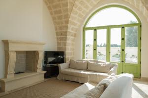 Una sala de estar con un sofá y una chimenea. en Masseria Egnazia - Epoca Collection, en Savelletri di Fasano