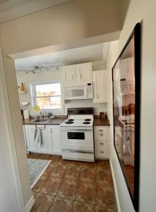 a white kitchen with a stove and a window at Chaleureux condo à Magog in Magog-Orford