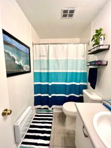 a bathroom with a blue and white shower curtain at Chaleureux condo à Magog in Magog-Orford