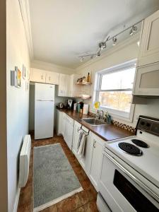 a kitchen with a white refrigerator and a sink at Chaleureux condo à Magog in Magog-Orford