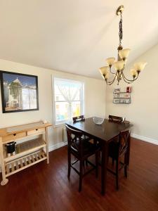 a dining room with a table and a chandelier at Chaleureux condo à Magog in Magog-Orford