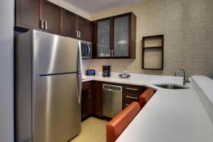 una cocina con nevera de acero inoxidable y armarios de madera en Residence Inn by Marriott Philadelphia Valley Forge/Collegeville, en Collegeville