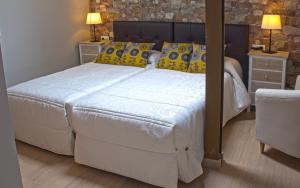 a bedroom with a large bed with yellow and blue pillows at Aire de Sanabria in El Puente