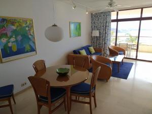 uma sala de estar com uma mesa e cadeiras e um sofá em Anfi del Mar 2 em La Playa de Arguineguín