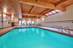 una piscina cubierta con agua azul en un edificio con techos de madera en Fairfield Inn & Suites Seattle Bellevue/Redmond, en Bellevue