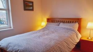 a bedroom with a large bed with two lamps at Beauly Holiday Home in Beauly