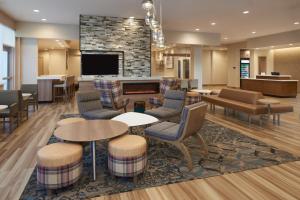 a hotel lobby with tables and chairs and a fireplace at Residence Inn by Marriott Toronto Mississauga Southwest in Mississauga