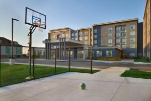 Residence Inn by Marriott Toronto Mississauga Southwest في ميسيساوغا: طوق لكرة السلة مع كرة على الأرض أمام المبنى