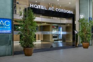 コルドバにあるAC Hotel Córdoba by Marriottのホテルの前に2本の木があるコボーダの建物