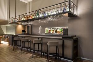 un bar con sgabelli e una mensola con bevande di AC Hotel Córdoba by Marriott a Cordoba
