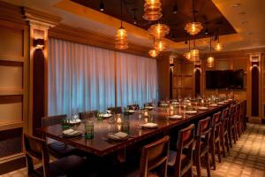 a long long table in a room with chairs and a television at MOXY NYC Times Square in New York