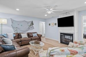 sala de estar con sofá y chimenea en The Blue Lagoon, en Pine Knoll Shores