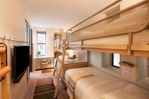 a room with two bunk beds and a television at MOXY NYC Times Square in New York