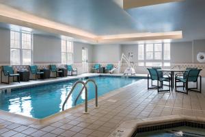a large pool with chairs and a table and a tablektop at Residence Inn Poughkeepsie in Poughkeepsie