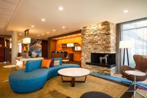 a living room with a blue couch and a fireplace at Fairfield by Marriott Cambridge in Cambridge