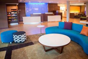 a living room with a blue couch and a table at Fairfield by Marriott Cambridge in Cambridge